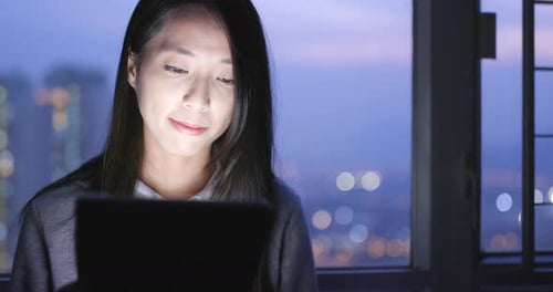 Woman use of tablet computer at night