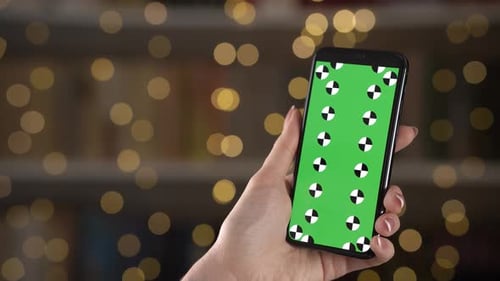 Woman Sliding Pages on a Smartphone with Tracking Points on Display Against Bokeh on Background