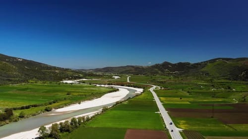 Lush Countryside Aerial with River and Winding Road