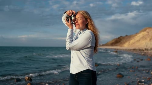 Photographer Using Slr Camera On Beach
