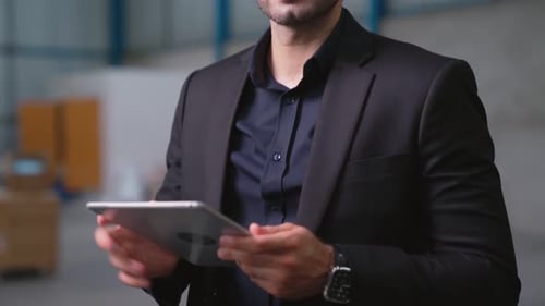 Factory Manager Using Tablet Computer in Warehouse or Factory
