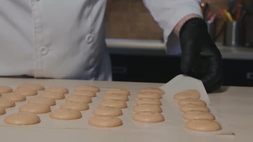 Baker Removing Macarons from Baking Paper