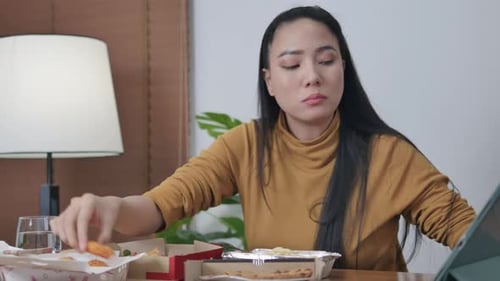 girl sitting at home on the sofa and watching movies on laptop