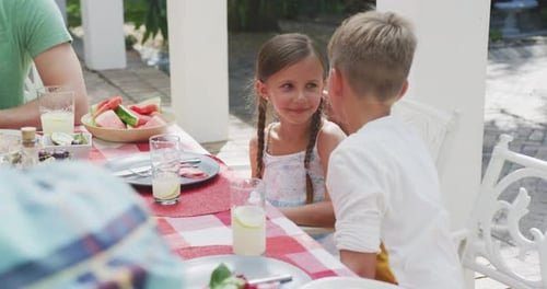 Family Gathering at Table with Lemonade and Watermelon