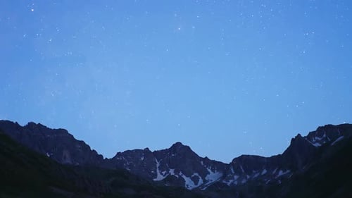 Stars Appear Over Mountain Range at Night