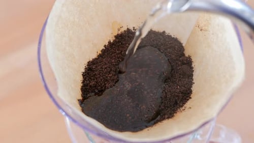 Pouring Water Over Fresh Coffee Grounds