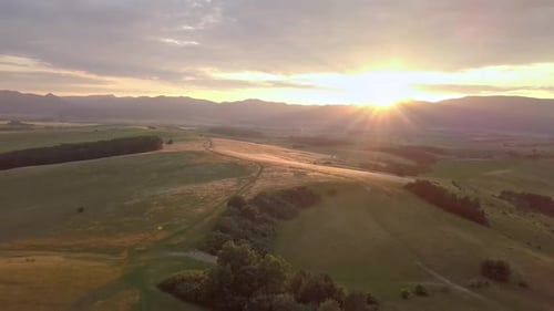 Golden Sunrise Over Rolling Hills Landscape