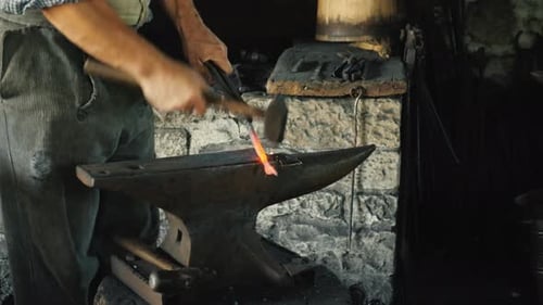 Blacksmith Shaping Metal on Anvil with Hammer