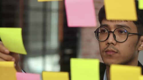 Group of Asian creative men workshop and brainstorm in front of mirror board.