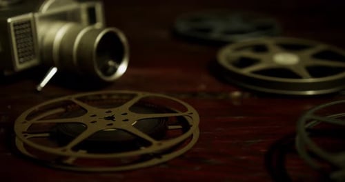Vintage Film Reels and Camera on Wooden Surface