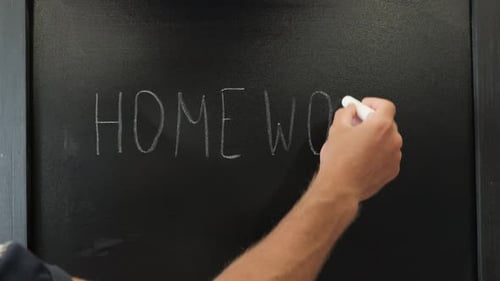 Männliche Hände schreiben Wörter HomeWork mit Kreide auf Tafel. Bildungs-Konzept