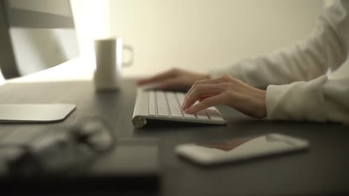 Hands Typing on Keyboard in Office Setting