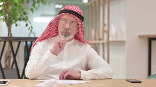 Senior Man Writing at Desk in Office