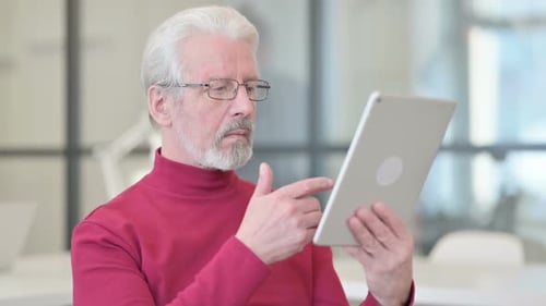 Senior Man Using Tablet in Office