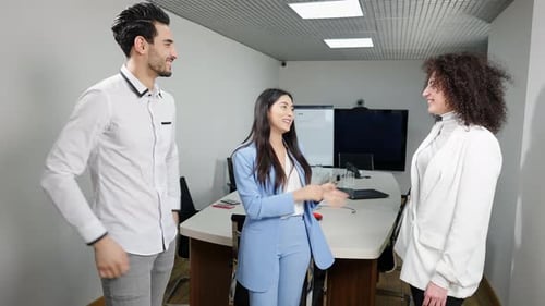 Portrait of Excited Asian Woman Talking with Positive Multiethnic Colleagues Standing in Office