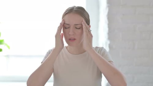 Woman Rubbing Temples During Headache Attack