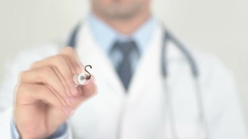 Severe Doctor Writing on Transparent Glass