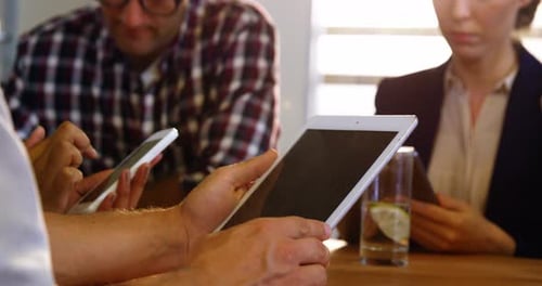 Business executives using mobile phone, digital tablet and laptop