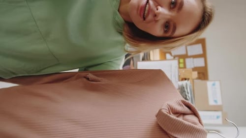 Woman Showing Stylish Sweater on Hanger to Camera