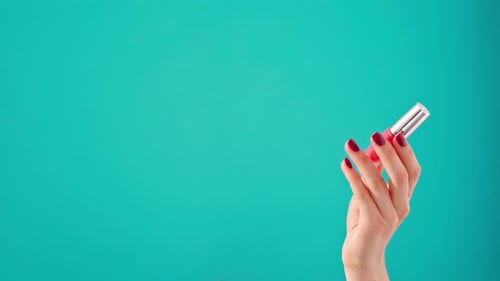 Woman's Hand Holding Pink Nail Polish