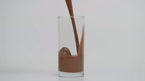 Super Slow Motion of Filling Transparent Glass with Chocolate Milk