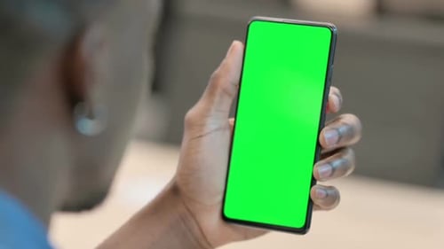 African Man Using Smartphone with Green Chroma Key Screen