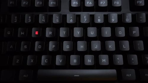 Computer Keyboard with Red Illumination Highlighting Letters