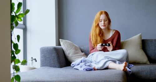 Woman Relaxing, Playing Video Game on Couch