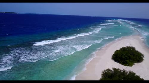 Aerial drone shot seascape of tropical island beach break by blue water with bright sandy background