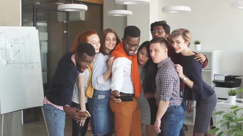 African Guy Taking Picture with His Multiracial Friends in the Modern Studio