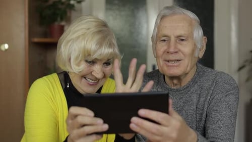 Senior Couple Using Tablet Device Together Indoors