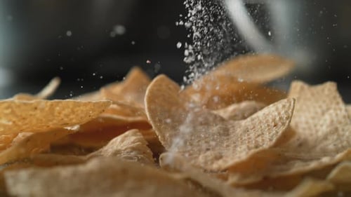 Adding salt on tortilla chips. Slow Motion.