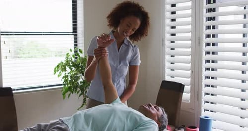Woman Assists Man with Arm Physical Therapy