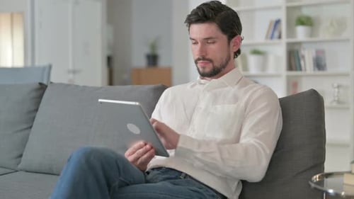Man Relaxing at Home While Using Tablet