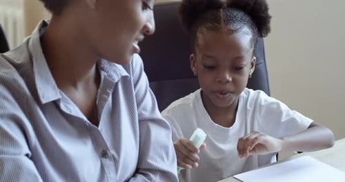 Woman and Child Drawing Together at Desk