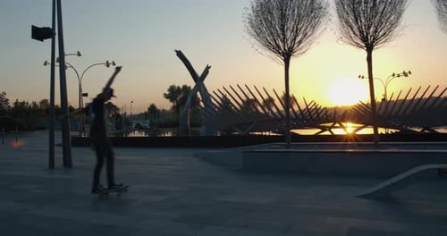 Skateboarder Is Having Fun at the Park in the Morning, Doing Tricks,