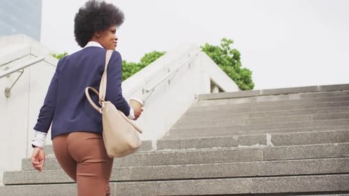 Young Professional Woman Climbing City Steps With Drink