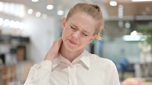 Young Woman Experiencing Neck Pain in Office
