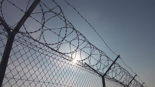 Chain Link Fence with Barbed Wire Silhouette