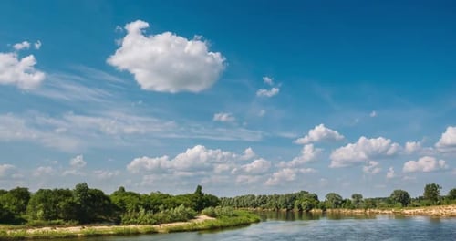 River Among Green Bushes and Trees with Clouds Above It