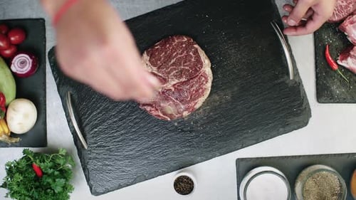 High Angle of Chef Seasoning Raw Meat