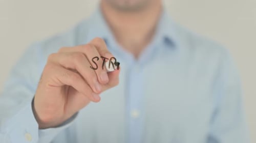 Man Writes Strategic Planning on Glass Board