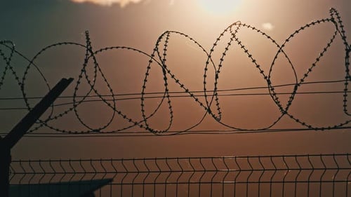Fence and Barbed Wire Silhouette at Sunset