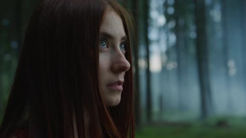 Young Woman Stares Dreamily Into Forest