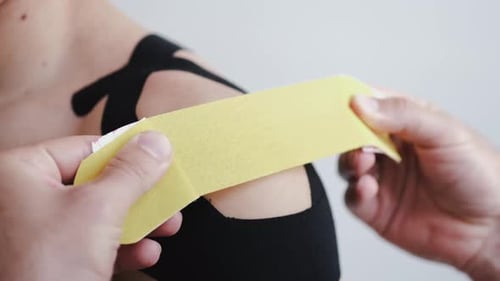 Applying Athletic Tape to Shoulder Muscle