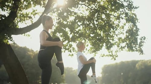 Two Women Practicing Yoga in Park