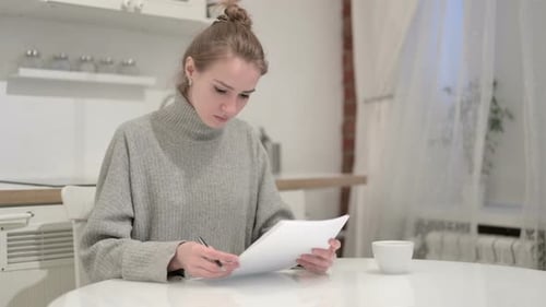 Distressed Woman Reviewing Documents at Home