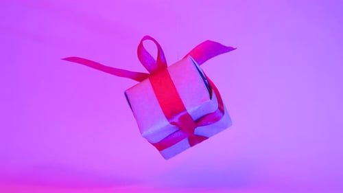 Rotating Gift Box with Red Ribbon on Pink
