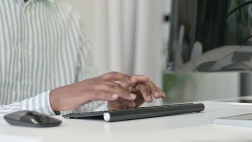 Close Up of African Man Using Mouse and Keyboard