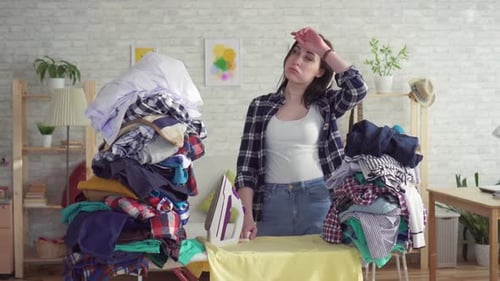Woman Ironing Clothes Looking Tired and Frustrated
